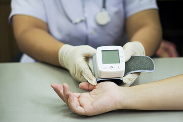 Nurse Using Wrist Blood Pressure Monitor for Patient Checkup