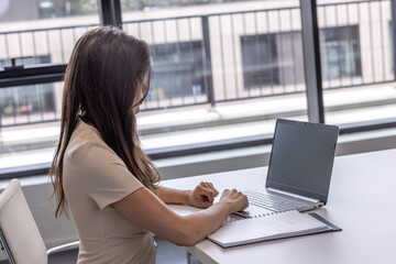 Businesswoman working on a laptop in modern office