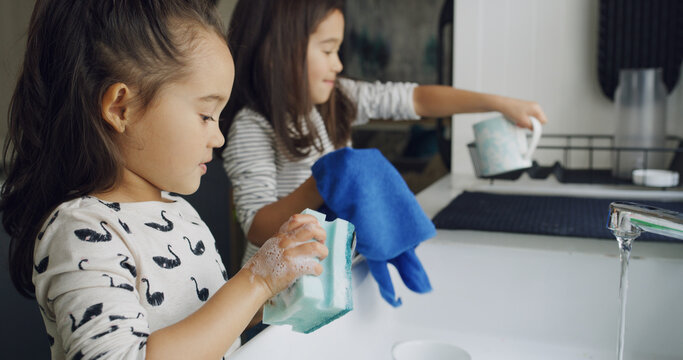 Cleaning, washing dishes and support with kids in kitchen for hygiene, help or domestic chores. Bacteria prevention, sanitary or housekeeping with siblings or children in family home for maintenance