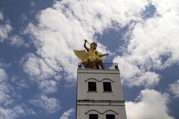 A striking statue of Saint Michael stands prominently along the roadside in Tharae District, Sakon...