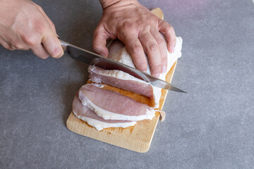 Slicing pork loin on cutting board