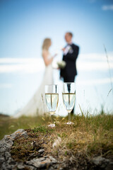 Bride and groom toasting behind two glasses of champagne
