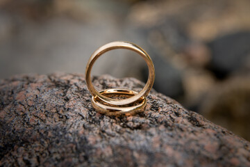 Wedding rings stacked on a rock
