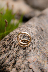 Wedding rings stacked on a rock
