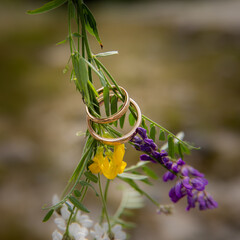 Wedding rings hanging in flowers
