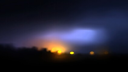 Blurry night scene with city lights and storm