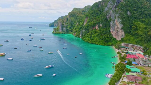 Embark on a visual journey above Koh Phi Phi island in Thailand as our flycam captures the stunning beaches, lush greenery, and crystal-clear waters of this tropical paradise. Discover the enchanting