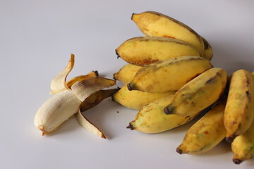 Ripe Chrapoovan bananas from Kerala, arranged in a natural cluster with one banana partially...