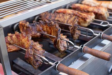 large spit loaded with pork is roasting