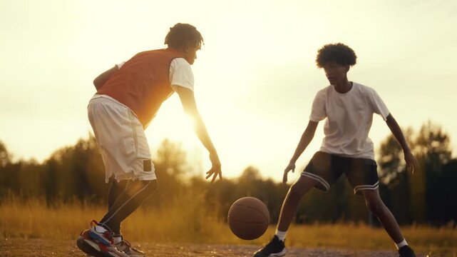 Streetballers practicing in summer, two african american teens playing together. Active pastime in vacation and weekend, do sport and developing power and endurance, workout outdoors, basketball
