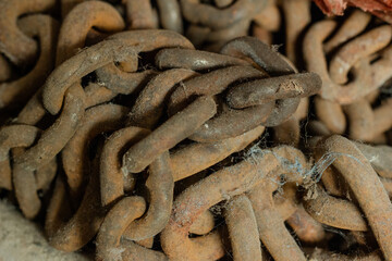 Macro close-up of old rusty metal chains covered in dust and cobwebs, showing corrosion, texture, and signs of aging