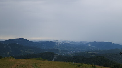 Obraz premium A tranquil scene of layered misty mountains and dense forests, perfect for travel promotions, nature-themed ads, and wellness campaigns