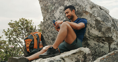 Man, phone and texting on mountain, hiking and rest with backpack, break and check route on digital...