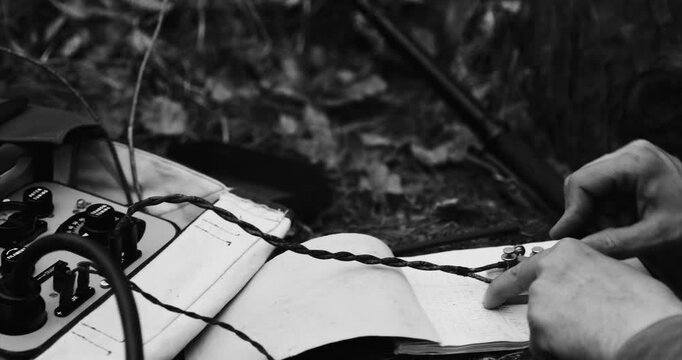 Historical Re-enactment Black And White Video. Russian Soviet Infantry Red Army Soldier In World War II using Russian Soviet Portable Radio Transceiver In Trench Entrenchment In Spring Autumn Forest