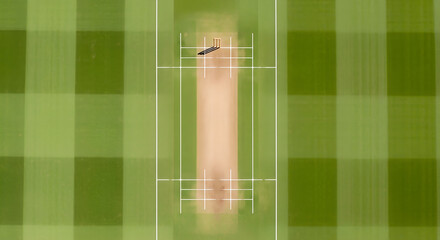 Cricket pitch with wickets and green grass from an aerial view