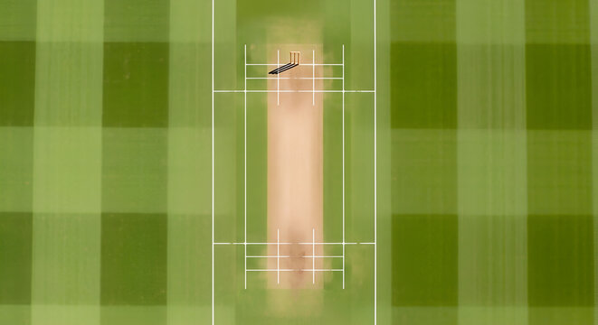 Cricket pitch with wickets and green grass from an aerial view - Powered by Adobe