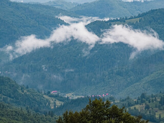 A sweeping view of green hills and distant mountains under a stormy sky, perfect for travel ads,...