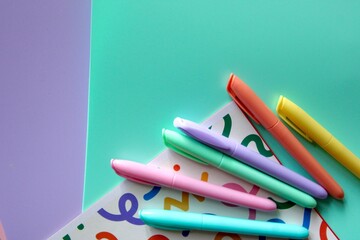 Flat lay composition of colorful school and art supplies arranged around a small easel with a blank...
