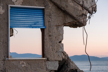 A beautiful but melancholic image of a window in a semi-destroyed house, offering a view of the sea...