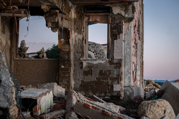 rubble of a seaside house photographed at sunset