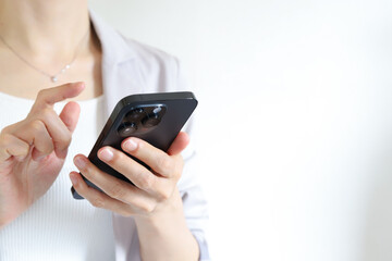 スマートフォンを使う女性の手元