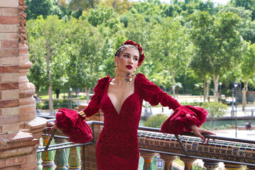 A beautiful woman dancing flamenco posing on the balcony with the park in the background in a...