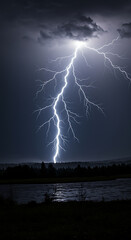 A dramatic image of a lightning strike illuminating a dark, stormy night sky over a river.