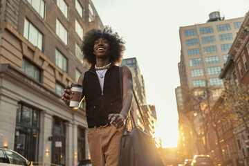 Laughing man walking with coffee in city light