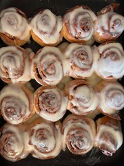 homemade baked cinnamon rolls covered with cream
