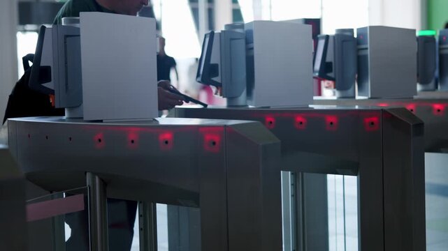 Passengers passing through automatic turnstile gates. Media
