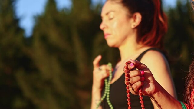 Yoga teacher meditating with mala beads in New Zealand