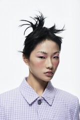 Close-up portrait of a young woman with striking makeup and unique hairstyle, dressed in a stylish...