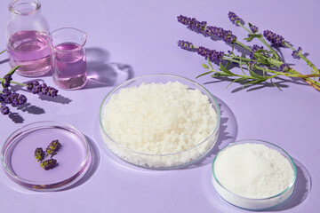 Side composition of lavender sprigs and bath salts in glass dishes on a soft purple background, suitable for aromatherapy, wellness, and skincare designs.