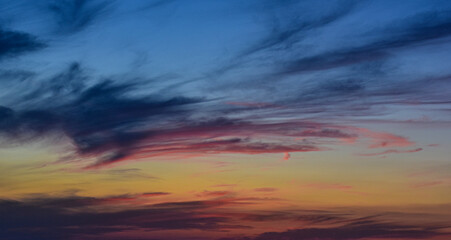 Fiery sunset colors in a peaceful sky with gradient gray clouds
