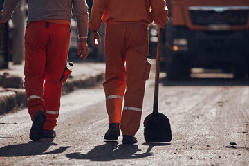 Fototapeta premium Construction workers working on a new asphalt layer on a public street.