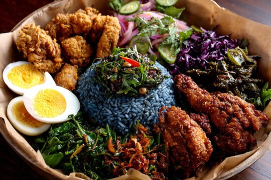 Traditional Kelantanese nasi kerabu with blue rice ulam-ulaman, budu and fried chicken 