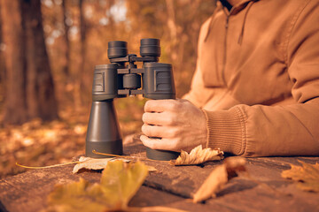 Naklejka premium Amateur birdwatcher observing birds and other animals in nature with binoculars.