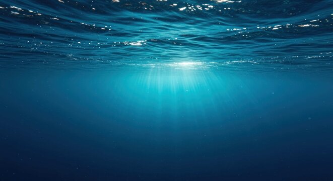 Underwater view shows light rays penetrating the water surface creating a bright glow.