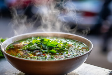 Steaming bowl of pho with fresh herbs, macro focus on broth surface, morning street food stall, 