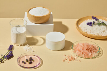 Glass jars, white bowl, pink salt, and lavender sprigs arranged neatly for skincare and body care advertising photography. Mockup unlabeled for design
