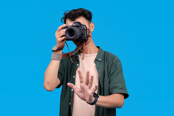 Photographer Holds His Camera Up To His Face, Taking A Picture While Showing Hold On Gesture