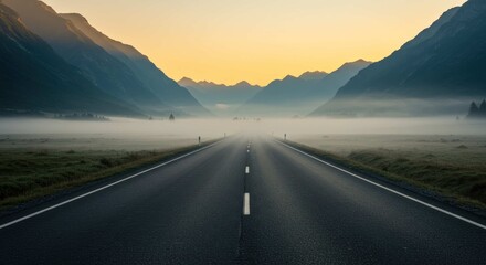 Naklejka premium Asphalt road stretches into distance with mountains and fog under a yellow sky.