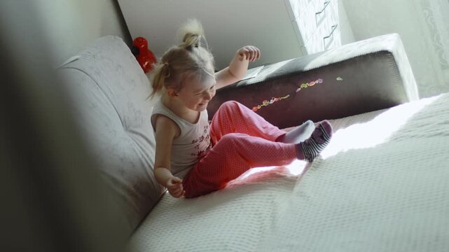 Offended three-year-old girl is sitting and crying on couch at home. Female baby child is freaking out. Children hysteria and psyche. Resentment grudge bitterness concept. Grief stress expression