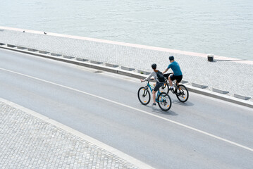 Two people cycling along the river