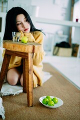 Contemplative Young Woman in Cozy Setting with Fruits.