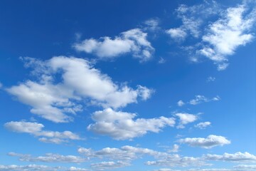 Obraz premium Vast expanse of a brilliant blue sky dotted with fluffy white clouds