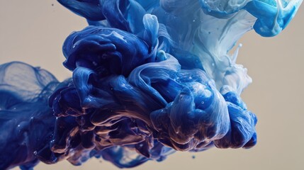 Fototapeta premium Abstract blue ink swirling in water, creating a dynamic and artistic visual effect with vibrant colors and fluid movement against a neutral background.