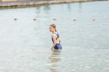 Portrait of happy girl sitting on inflatable ring in sea or ocean. Unchanged lifestyle, childhood,...