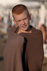 boy on the beach wrapped in a towel