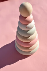 children's pyramid toy in pastel colors on a pink background